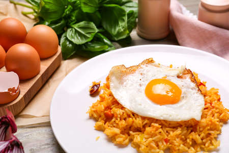 Plate with tasty egg and rice on table