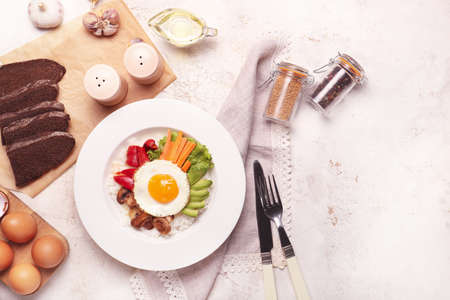 Plate with tasty egg, vegetables and rice on light backgroundの写真素材
