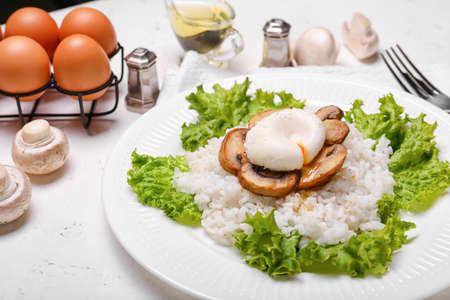 Plate with tasty egg, mushrooms and rice on light backgroundの写真素材
