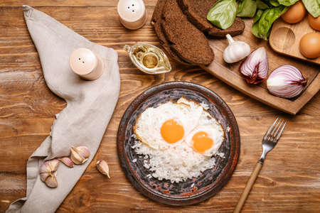 Plate with tasty eggs and rice on wooden backgroundの写真素材