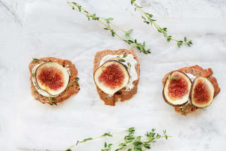 Tasty sandwiches with fig on light background
