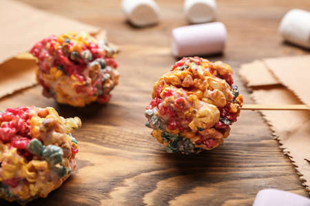 Tasty popcorn balls on wooden background