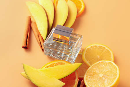 Composition with bottle of perfume and fruits on color background