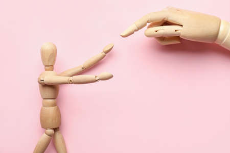 Wooden mannequin and hand on color backgroundの写真素材