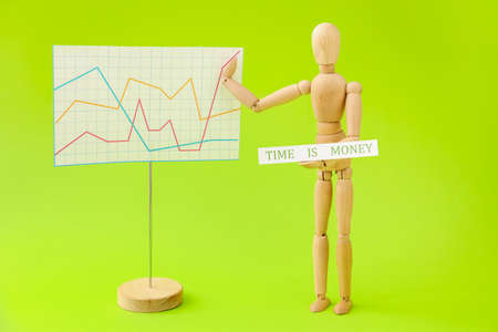 Wooden mannequin with words TIME IS MONEY on color backgroundの写真素材