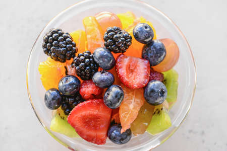 Glass with fruit salad on light backgroundの写真素材