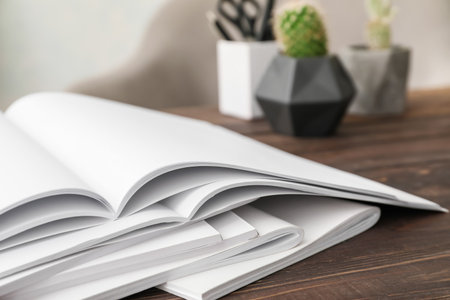 Open blank magazines on wooden table