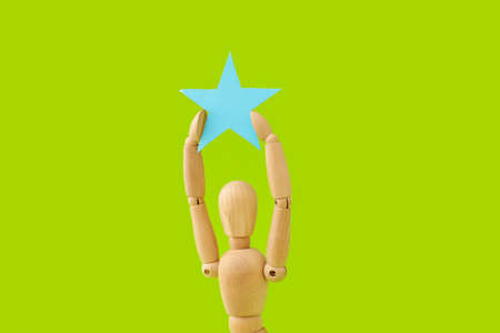 Wooden mannequin with star on color backgroundの写真素材