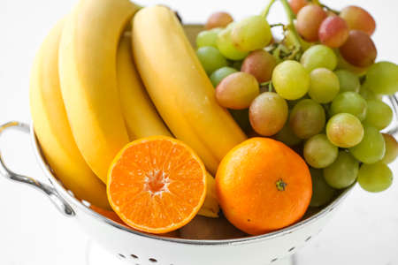 Colander with different fruits on white background, closeupの写真素材