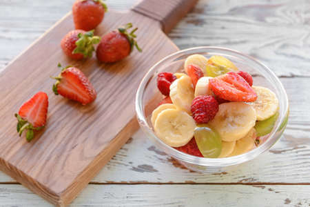 Bowl with fruit salad on wooden backgroundの写真素材