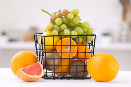 Basket with different fruits on table