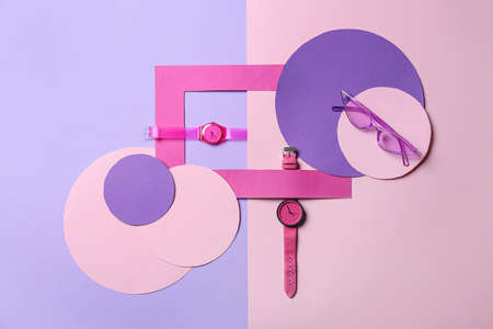 Composition with stylish wrist watches on colorful background