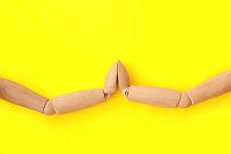 Wooden mannequins holding hands on color backgroundの写真素材