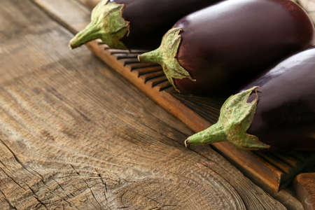 Fresh eggplants on wooden background