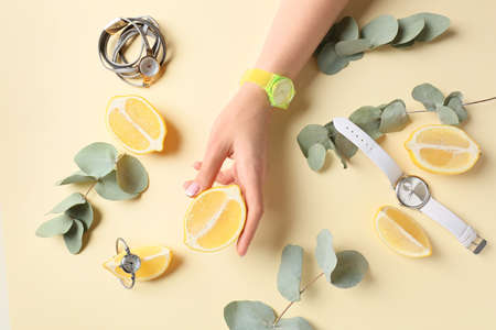 Female hand and stylish wrist watches on color backgroundの写真素材