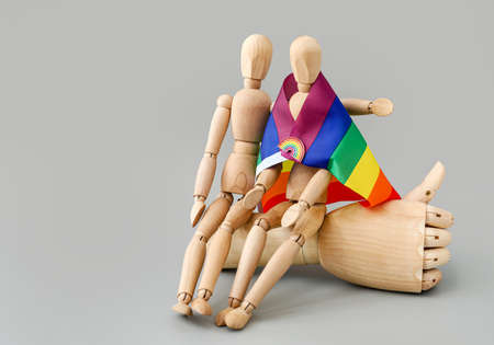 Wooden mannequins with rainbow flag on light backgroundの写真素材