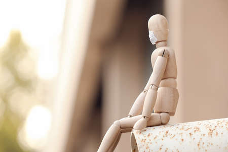 Wooden mannequin wearing medical mask outdoorsの写真素材