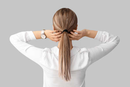 Woman with stylish wrist watch on light background