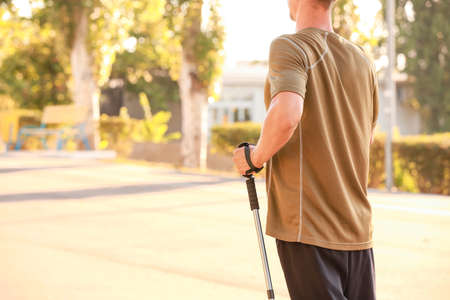Young man training with walking poles outdoorsの写真素材