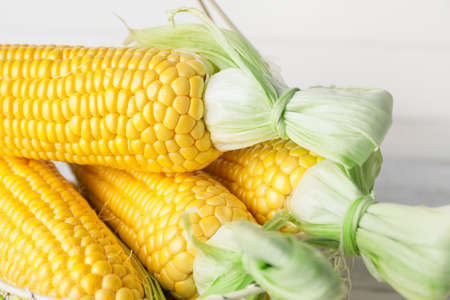 Fresh corn cobs in basket, closeupの写真素材