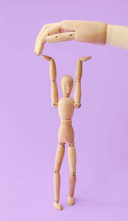 Wooden mannequin and hand on color backgroundの写真素材