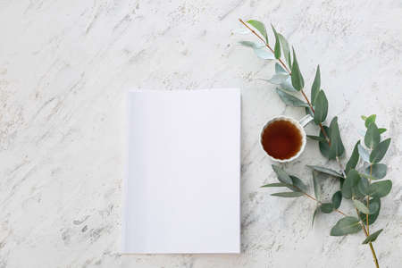 Blank magazine and cup of tea on light backgroundの写真素材