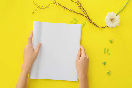 Woman holding blank magazine on color backgroundの写真素材