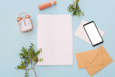 Blank magazine, alarm clock, perfume and mobile phone on color backgroundの写真素材