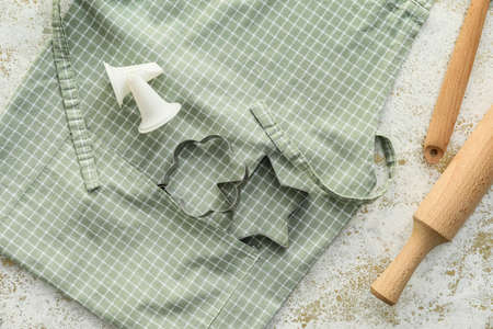 Apron, cookie cutters and rolling pin on light backgroundの写真素材