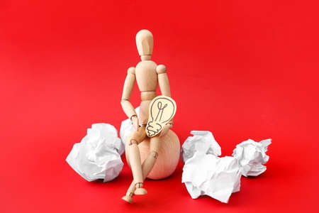 Wooden mannequin with drawn light bulb on color backgroundの写真素材