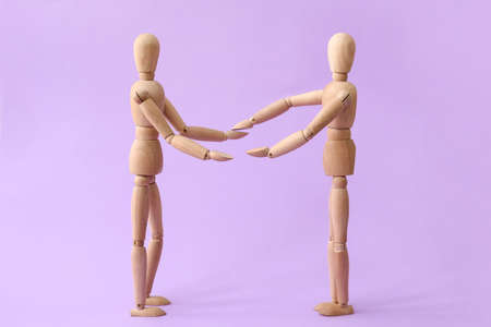Wooden mannequins on color background. Concept of support