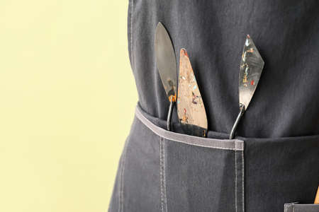 Female artist with palette knives on color backgroundの写真素材