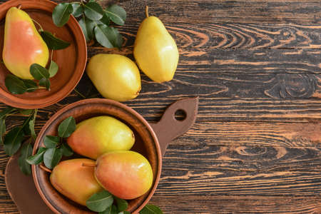 Composition with fresh pears on wooden background