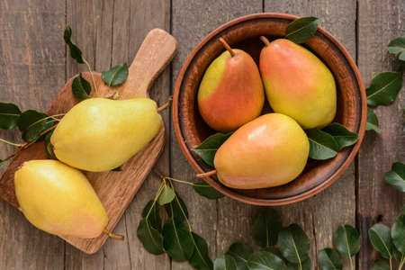 Composition with fresh pears on wooden background