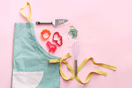 Set of kitchen utensils for bakery and apron on color backgroundの写真素材