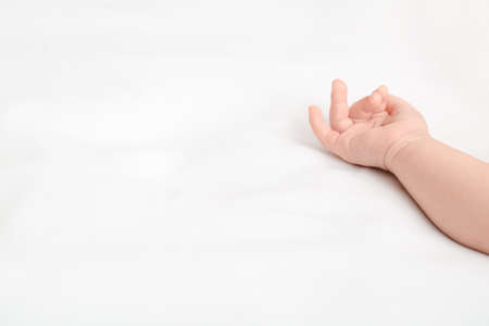 Hand of cute little baby lying on bedの写真素材