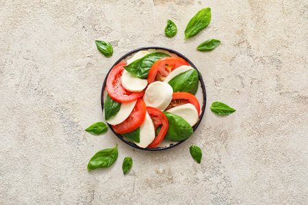 Plate with mozzarella cheese, tomatoes and basil on grunge backgroundの写真素材