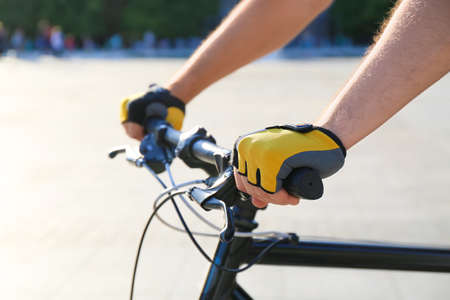 Male cyclist riding bicycle outdoors, closeup