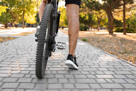 Male cyclist riding bicycle outdoors, closeupの写真素材