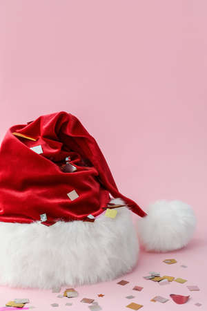 Santa Claus hat with confetti on color backgroundの写真素材
