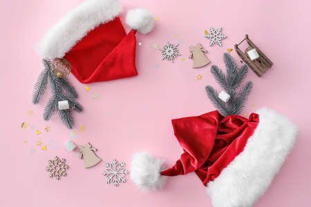 Christmas composition with Santa Claus hats on color backgroundの写真素材
