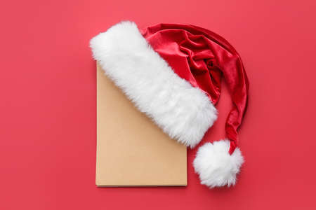 Santa hat and blank card on color backgroundの写真素材