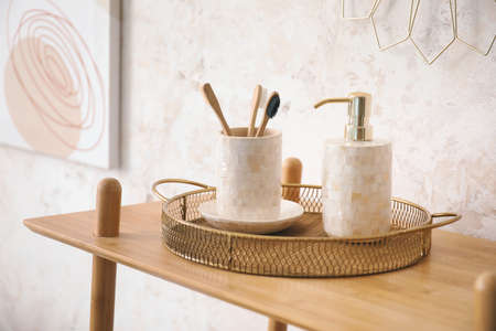 Rack with bath accessories near light wallの写真素材