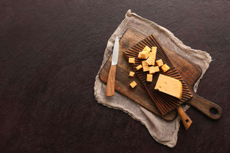 Tasty cut cheese on dark backgroundの写真素材