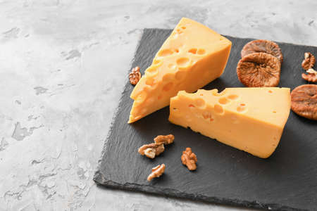 Composition with pieces of tasty cheese on light background