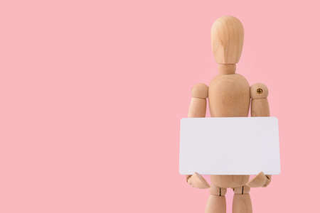 Wooden mannequin with blank card on color backgroundの写真素材