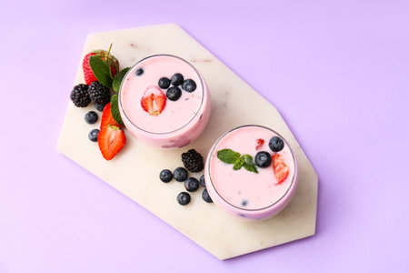 Glasses of delicious smoothie with berries on color backgroundの写真素材
