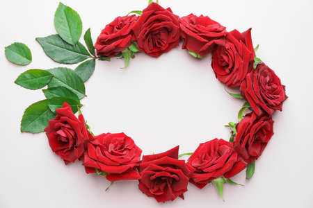 Frame made of beautiful red roses and leaves on light backgroundの写真素材