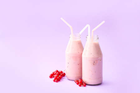 Bottles of delicious cranberry smoothie on color backgroundの写真素材