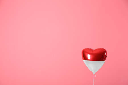 Heart shaped air balloon in colors of Indonesian flag on pink backgroundの写真素材